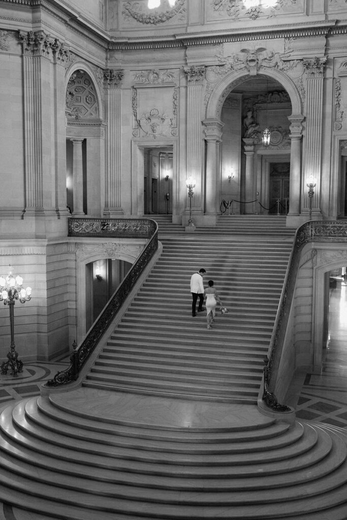 Wide view of a couple walking up a grand staircase 
