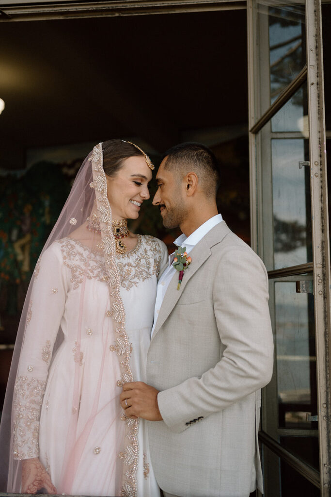 A couple in wedding clothes standing close together about to kiss 