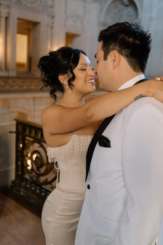 Newlyweds with their arms around each other about to kiss 