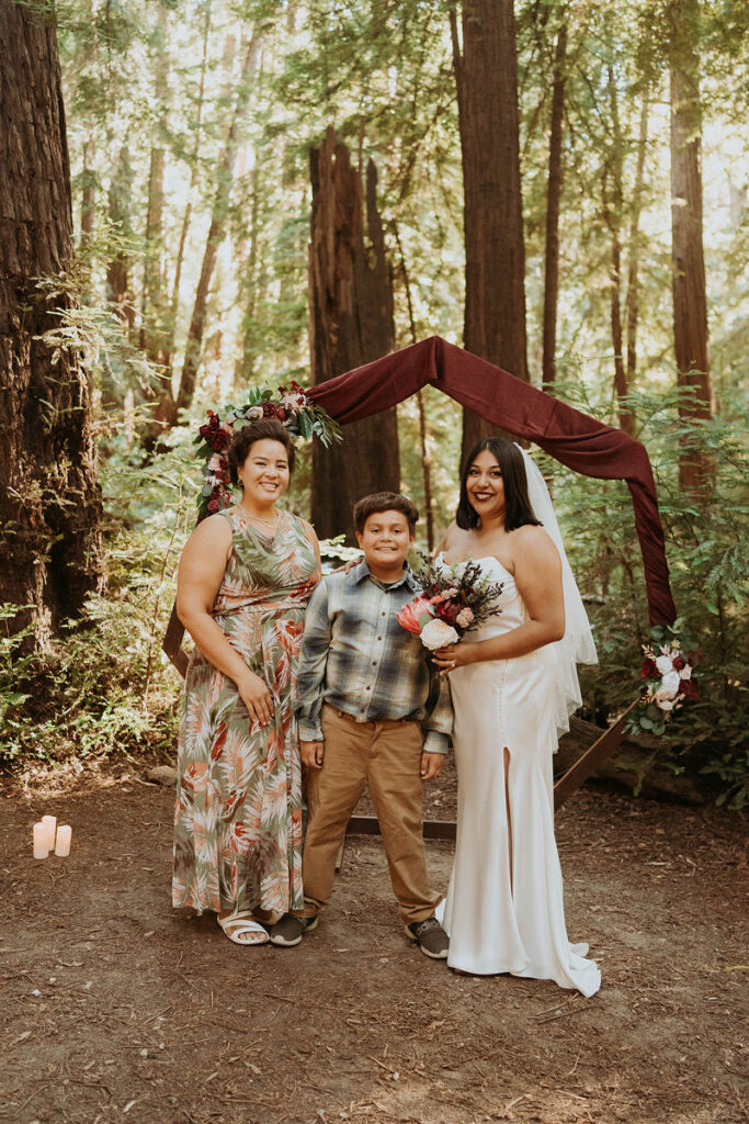 A newlywed standing with their siblings smiling at an outdoor elopement 