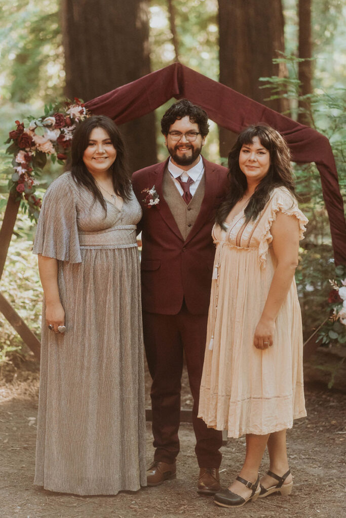 A newlywed standing with their family and smiling 
