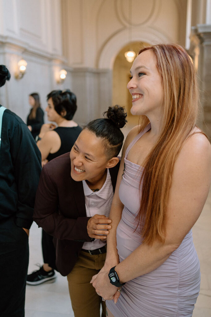 Wedding guests smiling and looking around at a wedding 